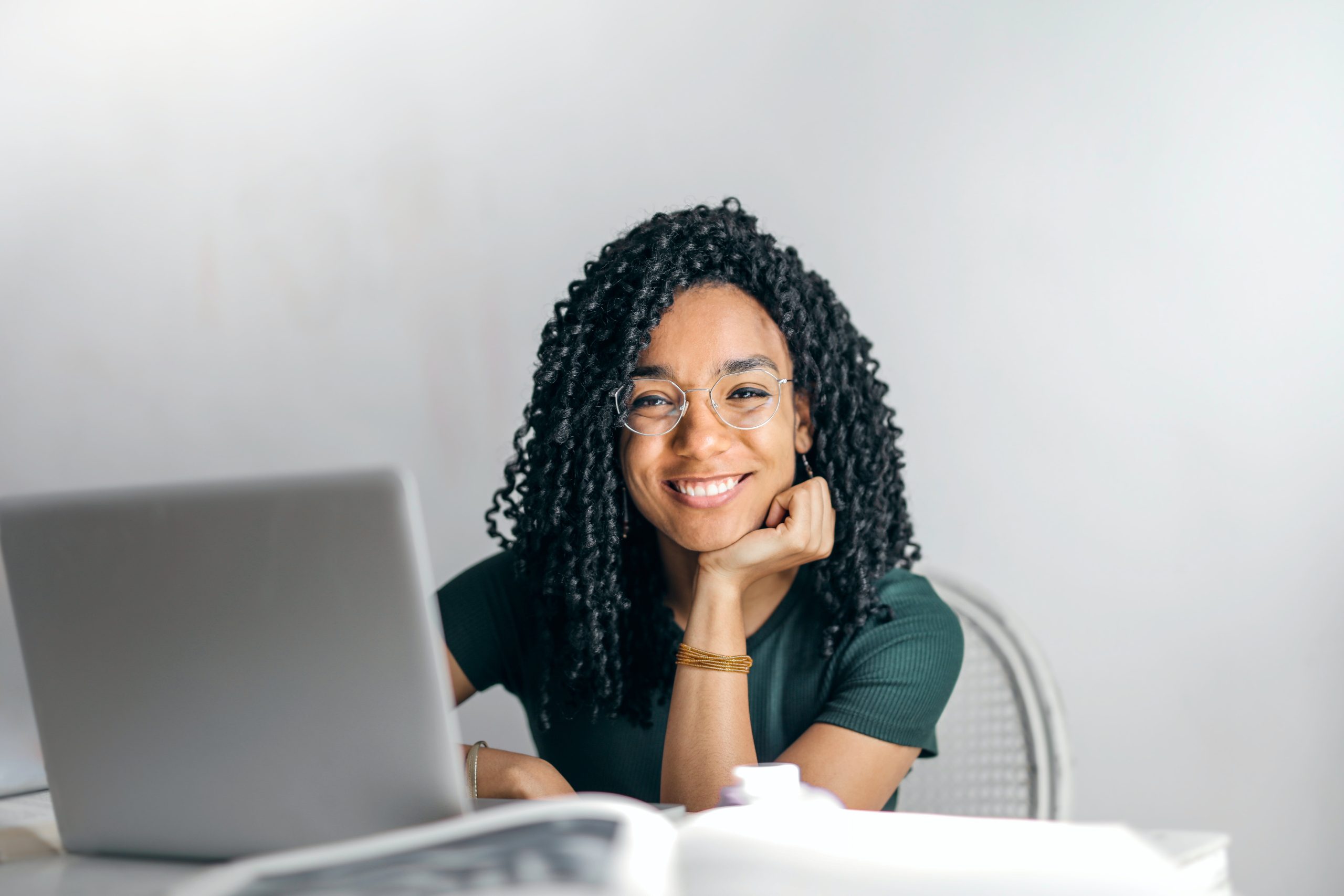 Happy female digital marketer smiling with a laptop in front of her
